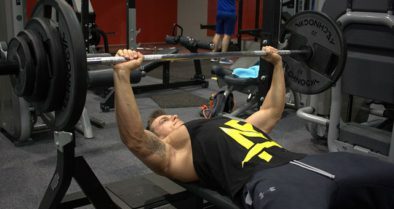 A weightlifter doing a bench press to maximize his chest muscles